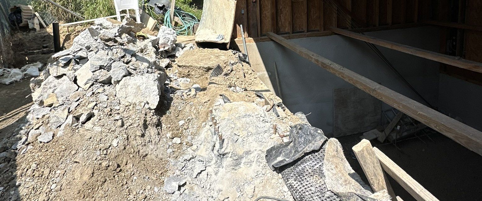 Excavated rock and soil beside the lower level of the Akopi Builders hillside custom home in Bel Air, under construction