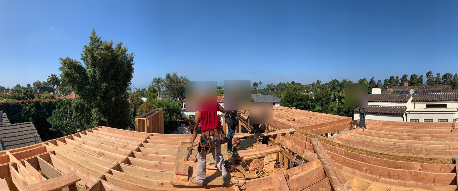 Akopi Builders crew on an active roof-framing build in Santa Monica, worker faces obscured for privacy