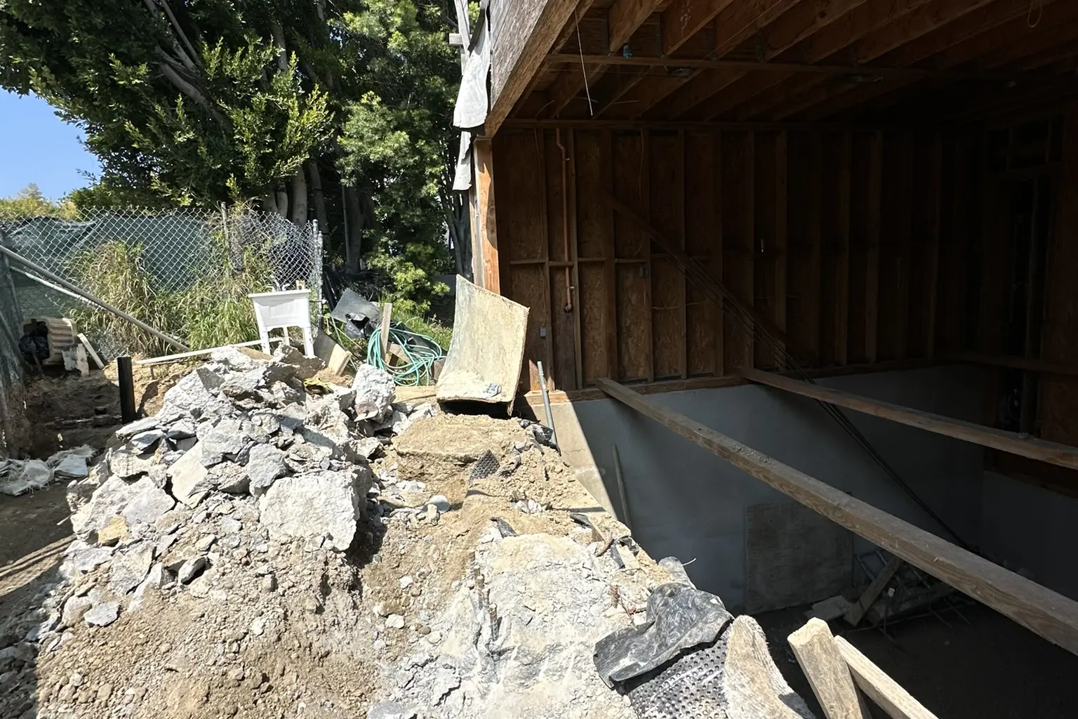 Excavated rock and soil beside the lower level of an Akopi Builders hillside custom home under construction in Bel Air.