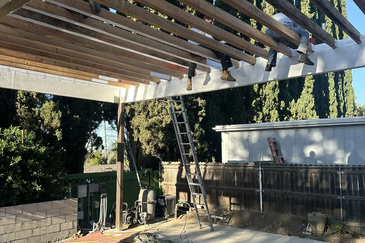 Looking up through new pergola rafters over a patio under construction at Arnwood, an Akopi Builders build in Los Angeles.