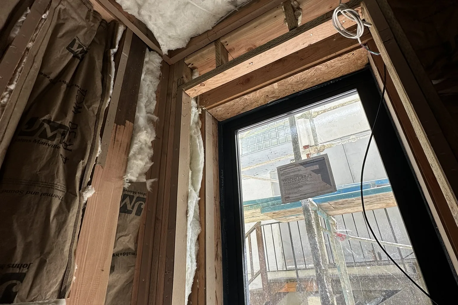 A framed room with insulation and a newly installed window on an Akopi Builders custom home under construction in Bel Air.