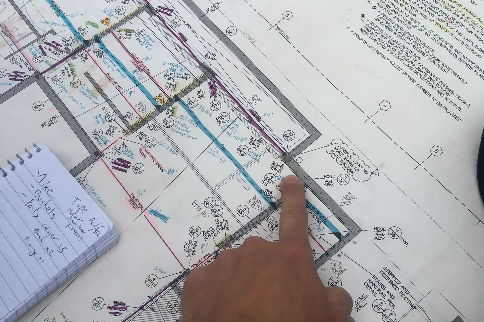 A hand pointing at a marked-up floor plan on an Akopi Builders project in Santa Monica.
